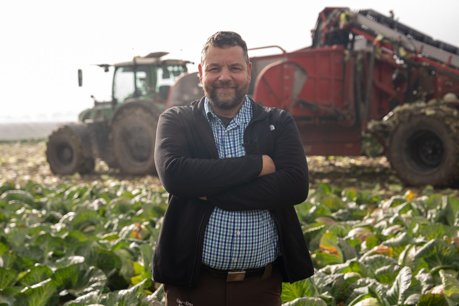 Business Fotografie Stuttgart – Landwirt vor Traktor und Erntemaschine im Kohlfeld