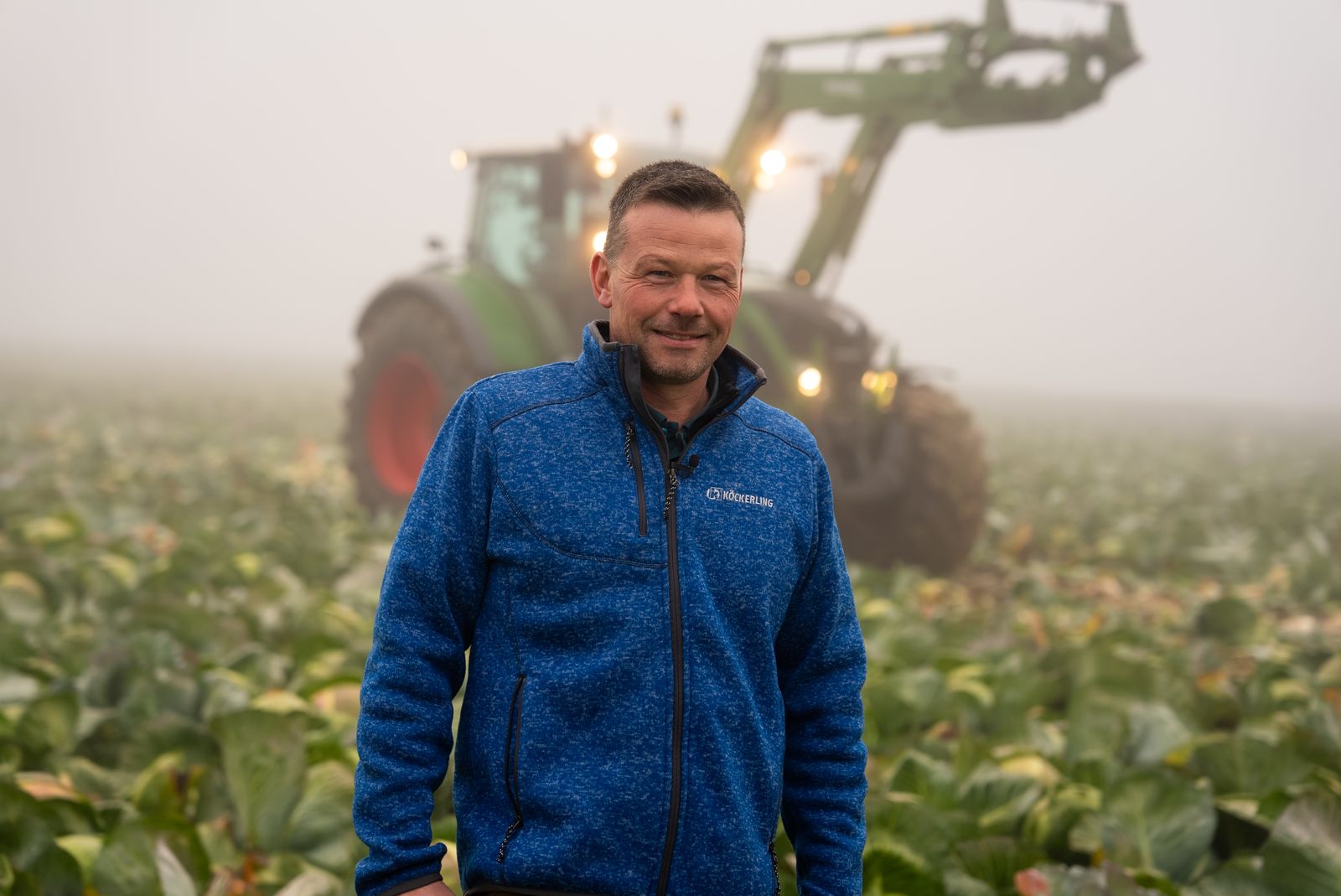 Unternehmensfotografie – Landwirt vor Traktor im Morgennebel