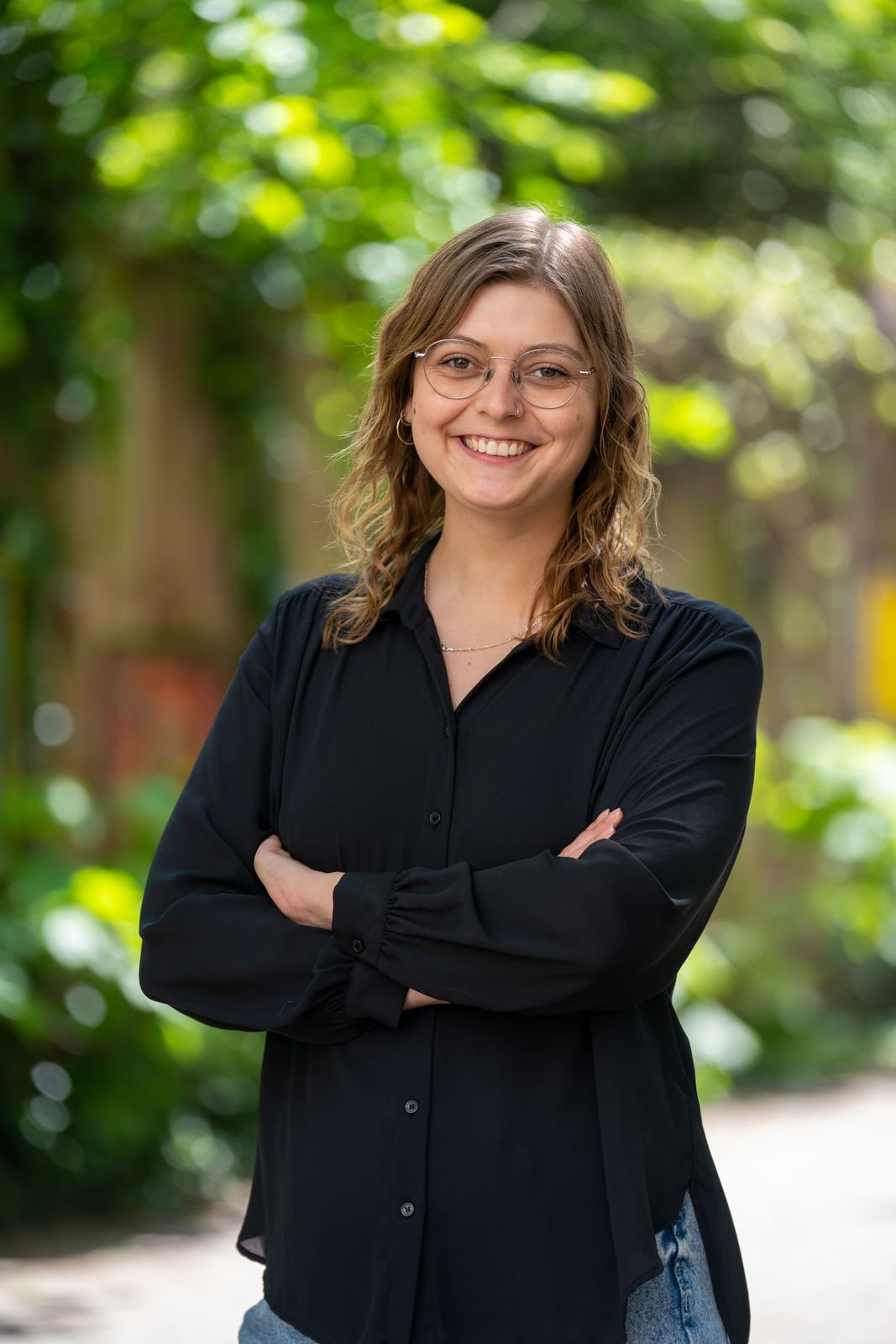 Business Portrait Fotografie Stuttgart – Frau im Freien vor grünem Hintergrund